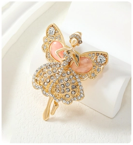 Detail showing a golden ballet dancer brooch with pink teardrop stones and white crystals