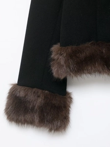 Detailed close-up of the plush brown faux fur cuffs on a black stylish short coat