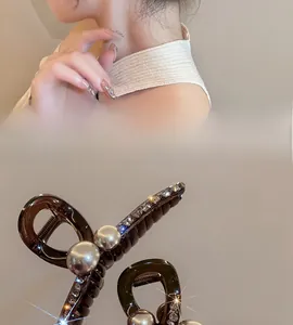 Detail of amber resin shark hair claw with white pearls and sparkling rhinestones