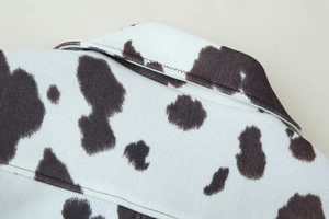 Détail de la couture du col et du motif vache sur une veste courte de style français