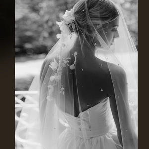 Macro detail of bridal veil featuring delicate pearls and 3D floral lace appliques