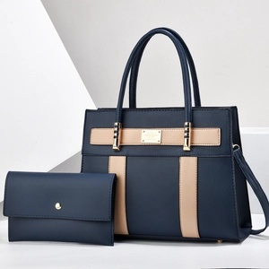 Detail of navy tote bag set featuring beige leather straps and gold metal hardware logo