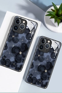 Macro detail of ink floral pattern on glass phone case with gold glitter accents