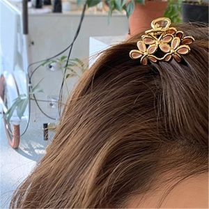 Detalle de una pinza para el pelo de flor dorada con diseño hueco para el peinado