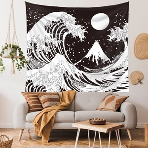 Close-up of black and white Great Wave tapestry hanging above a modern living room sofa