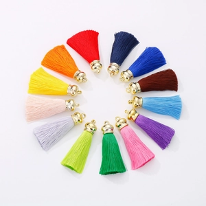 Macro shot of 13 multi-color silk tassels with golden caps arranged in a circular display