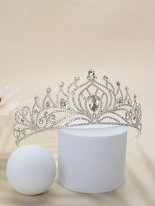 Detailed view of a silver bridal crown with sparkling teardrop rhinestones on a display