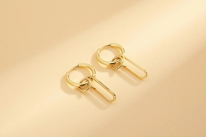 Detail of layered geometric gold hoop earrings with polished 18k gold plating finish