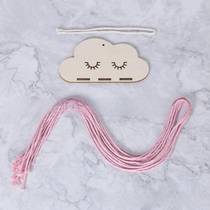 Flat lay of DIY cloud wood plaque with pink tassel and hanging cord for hair clips