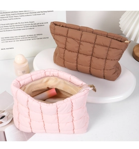 Internal view of a pink quilted cosmetic bag showing organized storage for makeup items.