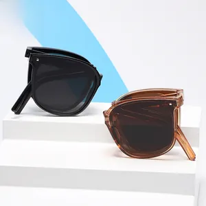 Detail view of foldable square sunglasses in black and amber with hinges for portability
