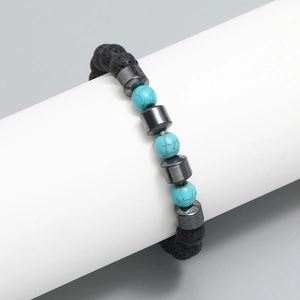 Men's volcanic lava stone beaded bracelet with turquoise accents on a white display stand