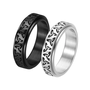 Close-up of black and silver Celtic knot spinner rings with rotatable stainless steel band