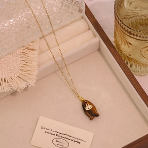 Nahaufnahme der goldenen Fisch-Halskette mit braunem Tigerauge-Stein und Zirkonia