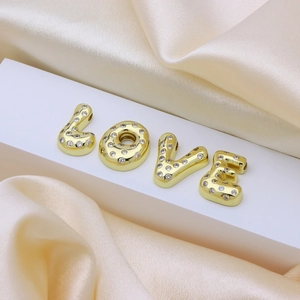 Gold balloon style LOVE letters necklace pendant with cubic zirconia inlay on silk