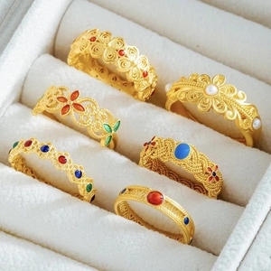 Set of vintage butterfly and floral gold rings with colorful enamel in a jewelry box