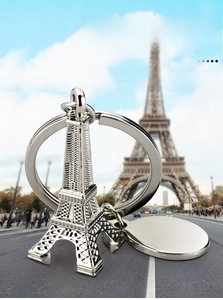 Detailed shot of silver 3D Eiffel Tower keychain with engravable round metal tag