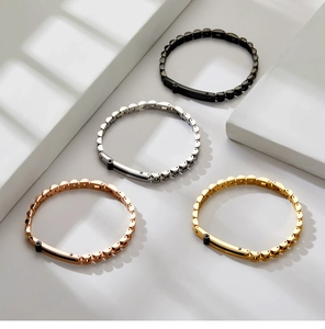 Detail of geometric link bracelets in gold, rose gold, silver, and black stainless steel