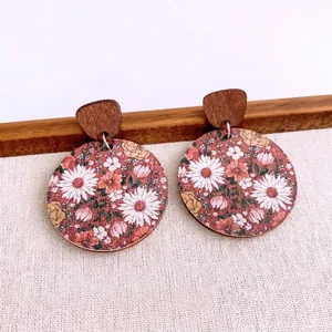 Minimalist round wooden floral earrings with pink daisies and green leaf patterns