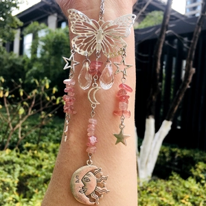 Detail of silver butterfly suncatcher with pink crystal stones and sun-moon charm