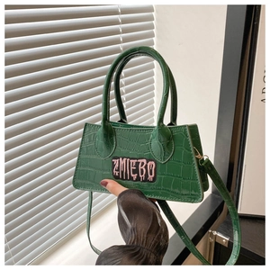 Detail of dark green embossed crocodile texture handbag with ZMIEBO embroidery patch
