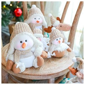 Detail of plush Christmas snowmen and reindeer figures with knitted hats on wood