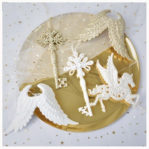 Golden unicorn and angel wing Christmas ornaments on a decorative tray with stars