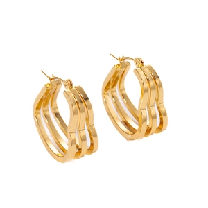 Detailed macro view of triple-layered golden wave hoop earrings with polished finish