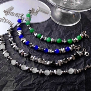 Detailed view of four beaded bracelets featuring cat-eye stones and industrial steel beads
