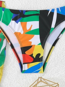 Dettaglio dello slip bikini con vivaci stampe floreali tropicali e motivi geometrici