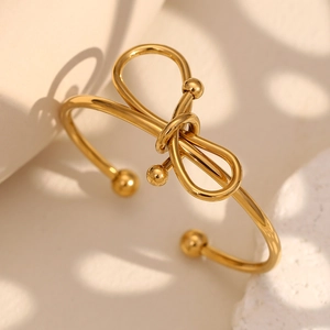 Détail macro d'un bracelet nœud plaqué or 18 carats sur pierre avec ombres douces