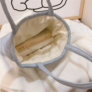 Top view of blue quilted heart tote bag showing interior space with books inside