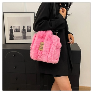 Detail of pink plush tote bag with Have a Nice Day patch worn by a model