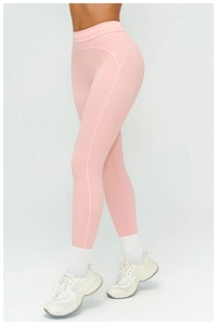 Detail view of pink yoga leggings showing contrast stitching and high-waisted fit on model