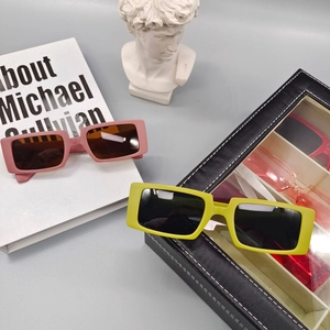 Vue détaillée de lunettes de soleil rectangulaires roses et jaunes avec un étui noir