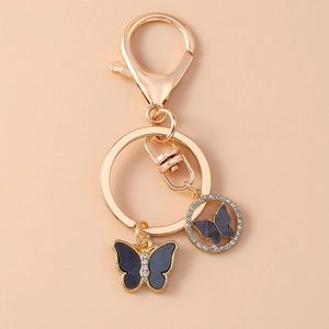 Detail of a gold-plated keychain with black enamel rhinestone butterfly charms and lobster clasp