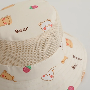 Detailed close-up of kids mesh sun hat with cute cartoon bear and strawberry prints