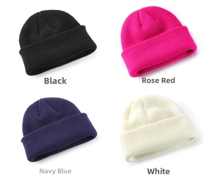 Detailansicht gestrickter Beanies in Schwarz, Rosarot, Marineblau und Weiß