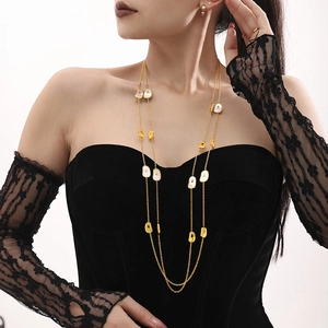 French style long gold layered necklace with white natural shell pendants on model