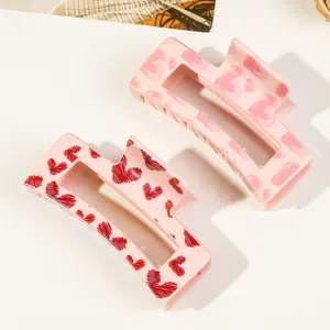 Detail shot of pink heart print hair claws featuring rectangles and doodle patterns