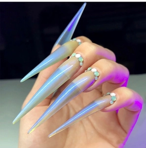 Dettaglio macro di unghie stiletto lunghe con finitura olografica e piccoli strass applicati