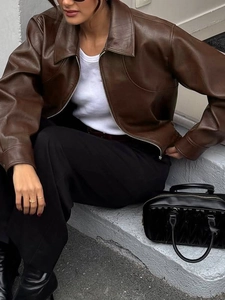 Close-up of a women's brown faux leather jacket with classic lapel and zipper detail