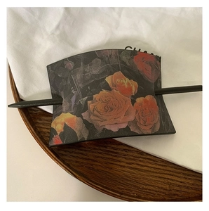 Détail d'une épingle à cheveux carrée en cuir vintage avec motif rose foncé