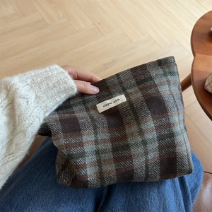 Close-up of vintage plaid wool fabric pouch featuring a simple wish cloth label