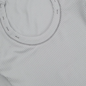 Detailed close-up of light gray ribbed knit fabric and crew neck stitching on a bodysuit