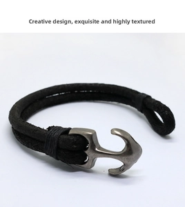 Detail of vintage men's braided black leather bracelet with silver anchor clasp