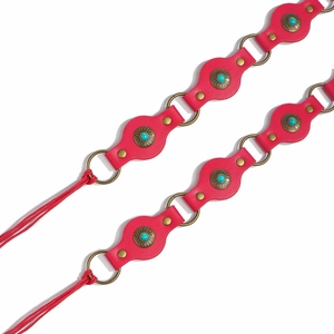 Detail of red leather belts with turquoise stone floral buckles and tassel accents