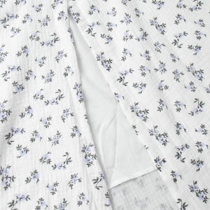 Detailed close-up of breathable cotton crepe fabric with delicate purple floral print