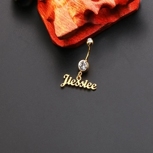 Detail of a golden belly ring with cubic zirconia and a custom Jessiee name pendant