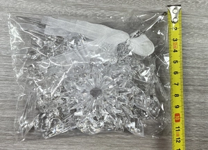 Detailed view of clear acrylic snowflake and teardrop ornaments with hanging ribbons